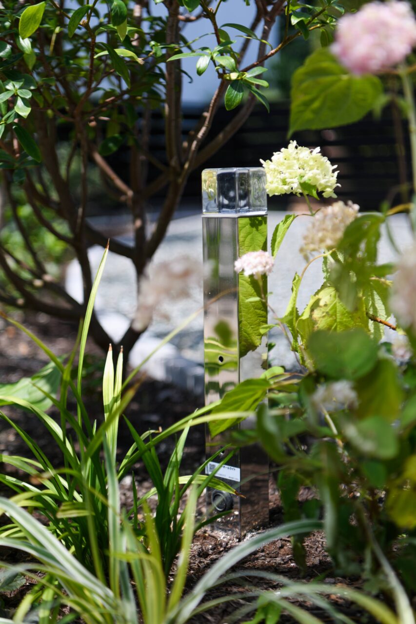 福岡市中央区の新築外構。LIXIL「美彩シリーズ」のローポールライトを採用し、鏡面加工が景色を映し込むことで光の存在感を引き立てる上質なライティングデザイン。｜ウェルミカ