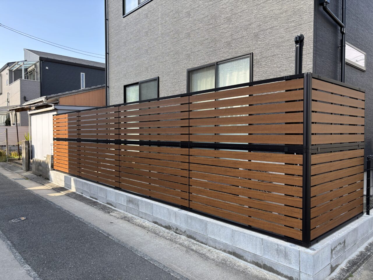 福岡市東区で施工した外構リフォーム。YKKルシアスフェンスYS2H型（キャラメルチーク×カームブラック）の完成後全体外観｜ウェルミカ