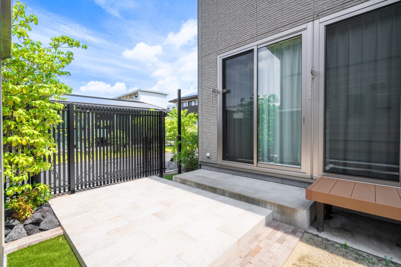 福岡県北九州市小倉南区の外構リフォーム施工後。リビングから続くタイルデッキと縦格子フェンスがつくる上質なプライベートガーデン。