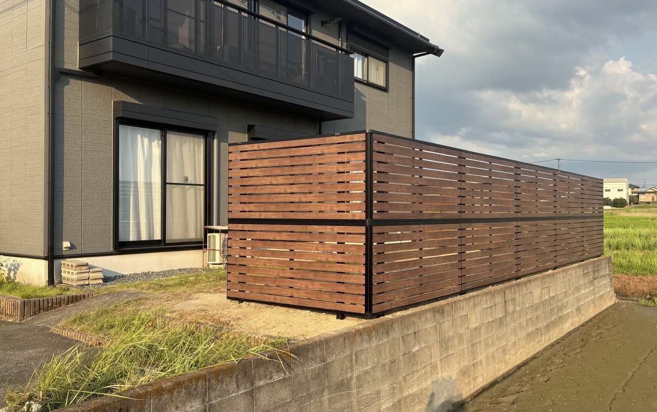 福岡県朝倉市の外構リフォーム施工後。建物の外観に美しくマッチする、三協アルミの木調目隠しフェンス「シャトレナⅡ」を設置したお庭の様子。